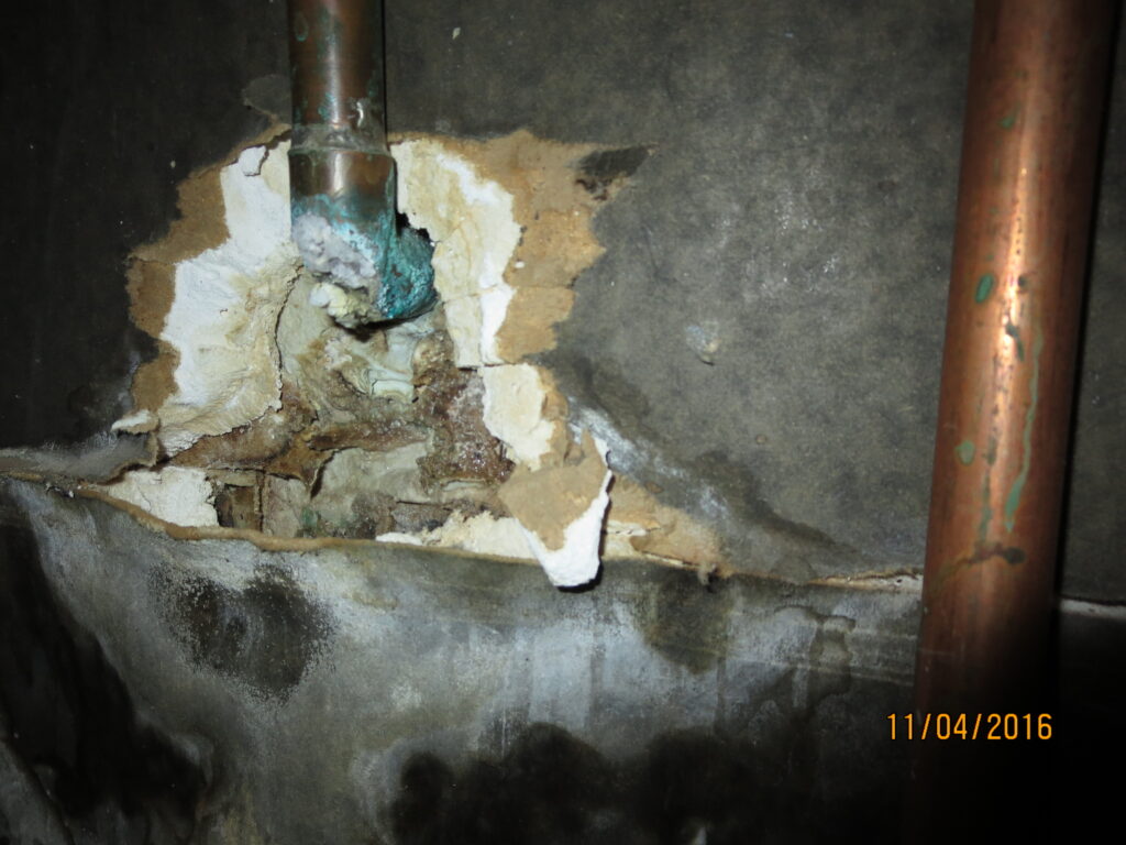 Photo of a plumbing leak in a wall.